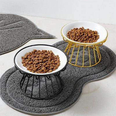 Gamelle chat ErgoGam™ en céramique avec des supports surélevés en fer noir et l'autre doré sur tapis